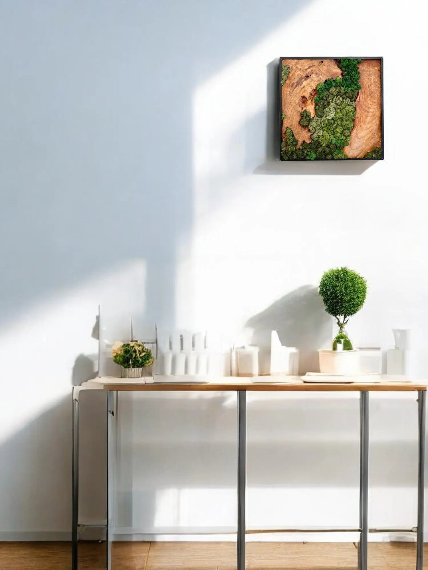 bright day with square shape wall decors of cedar wood with variety of green colored preserved moss hanging on the wall with plant decors sitting on a console table