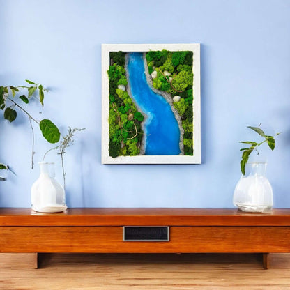 Epoxy and moss wall art with a sky-blue epoxy river design displayed on a side table with zen-inspired decor and plants. Creates a tranquil and natural atmosphere in any room